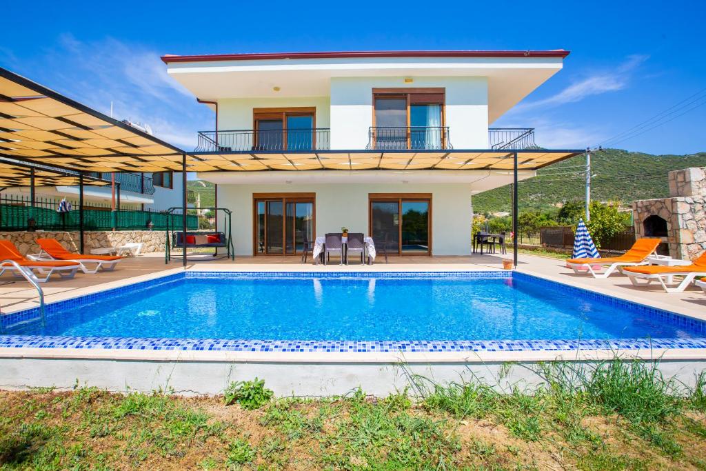 a villa with a swimming pool and a house at Kuytu Kaş Houses in Kas