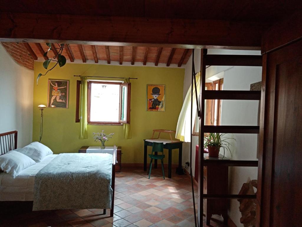 a bedroom with a bed and a window and a table at Casa di Laura in Chianciano Terme