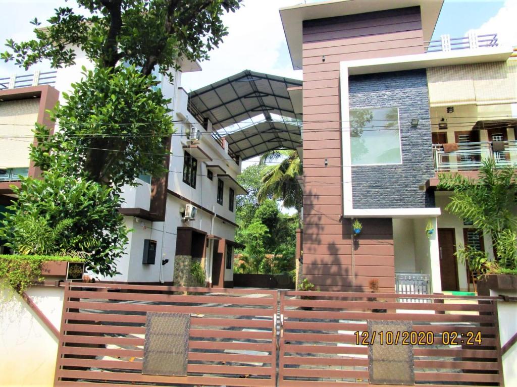 a house with a wooden fence in front of it at His grace villas in Kottakkal