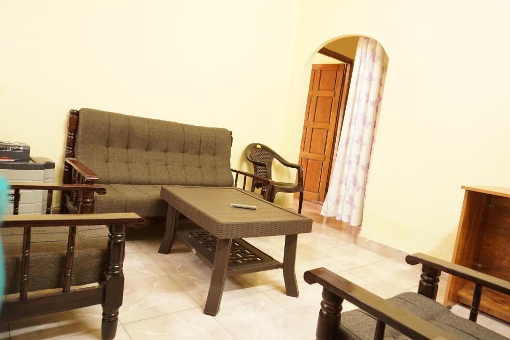 ein Wohnzimmer mit einem Sofa und einem Tisch in der Unterkunft BREEZ VILLA in Madikeri