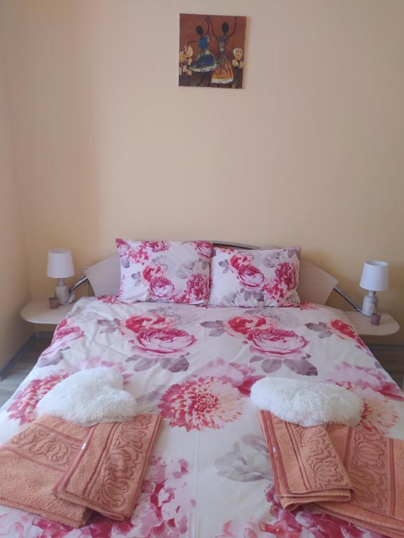 1 cama con 2 almohadas y colcha de flores en Raia, en Stara Zagora