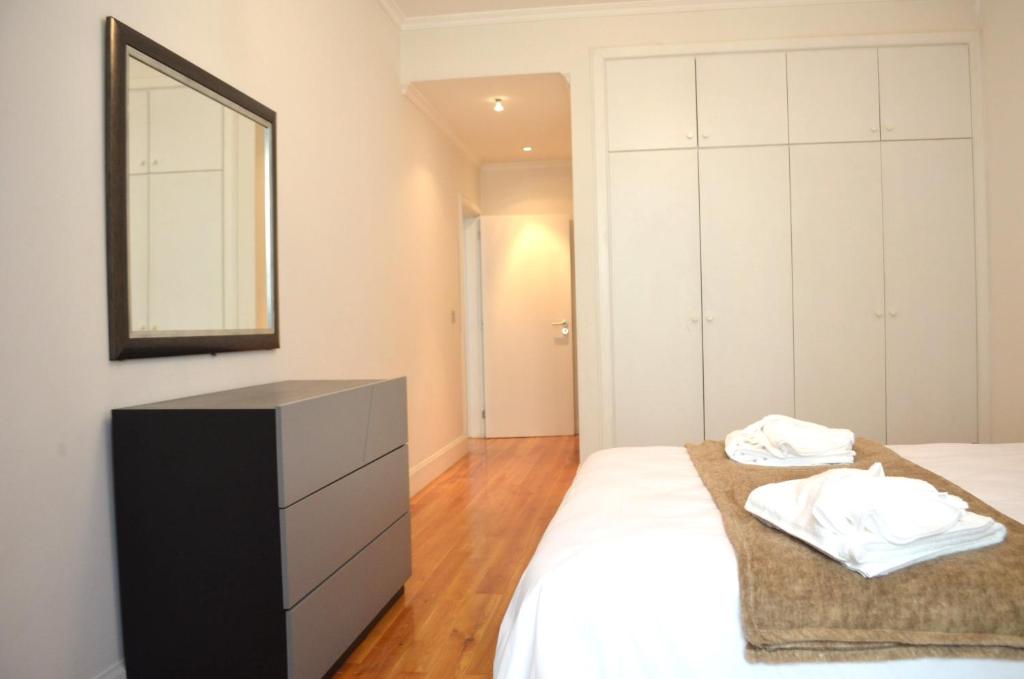 a bedroom with a bed with a dresser and a mirror at ғᴜɴᴄʜᴀʟ ᴄᴇɴᴛᴇʀ- ᴅᴏᴡɴᴛᴏᴡɴ in Funchal