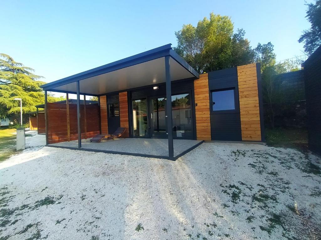 une petite maison avec un toit noir dans l'établissement Mobile Homes Istria - Brioni Pula, à Pula