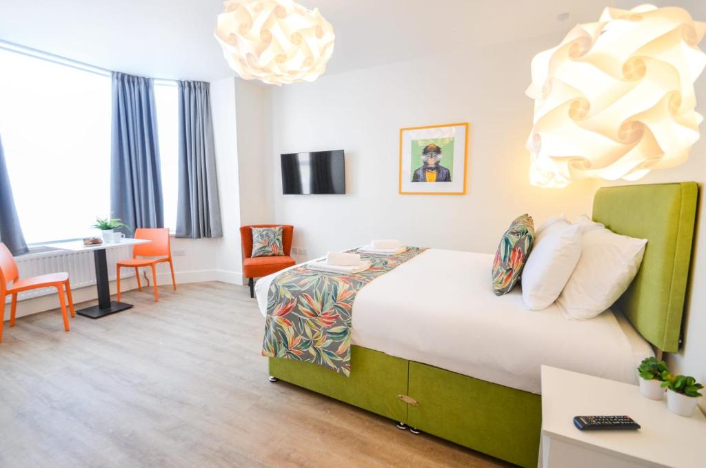 um quarto de hotel com uma cama, uma mesa e cadeiras em The Birchover Residences Trent Bridge em Nottingham