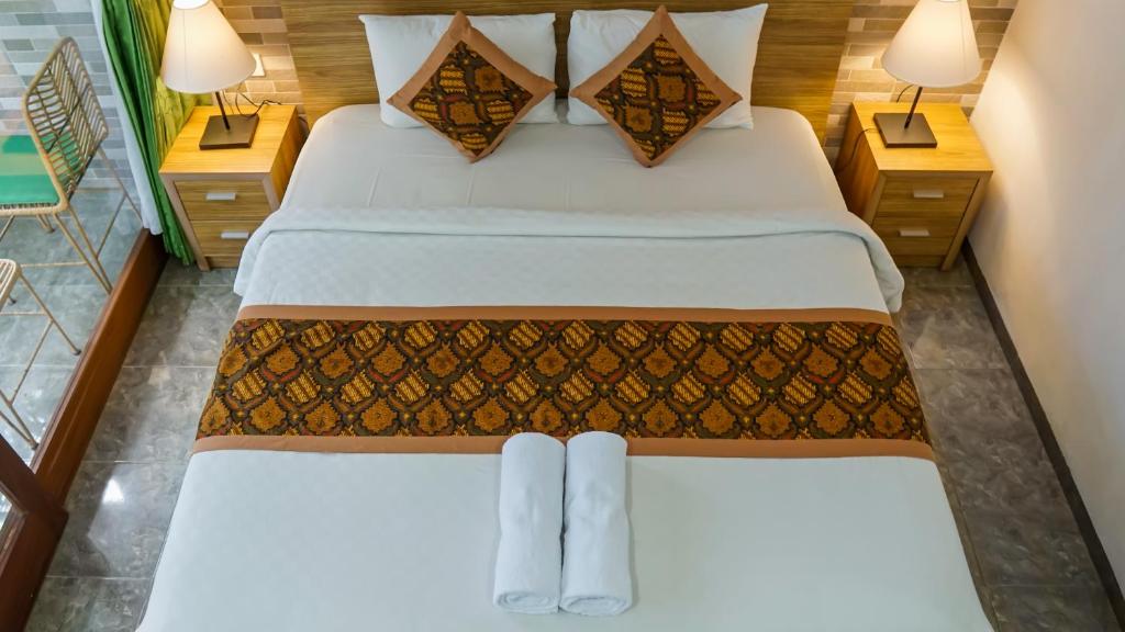 Postel nebo postele na pokoji v ubytování Pondok Pekak Guesthouse