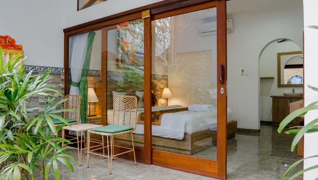 1 dormitorio con 1 cama y puerta de cristal en Pondok Pekak Guesthouse en Ubud