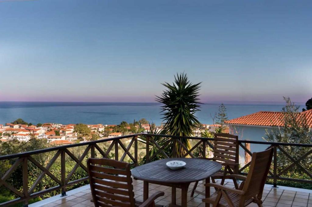 una mesa y sillas en un balcón con vistas al océano en Villa Mitsa with stunning view on the Argassi hill en Argasi
