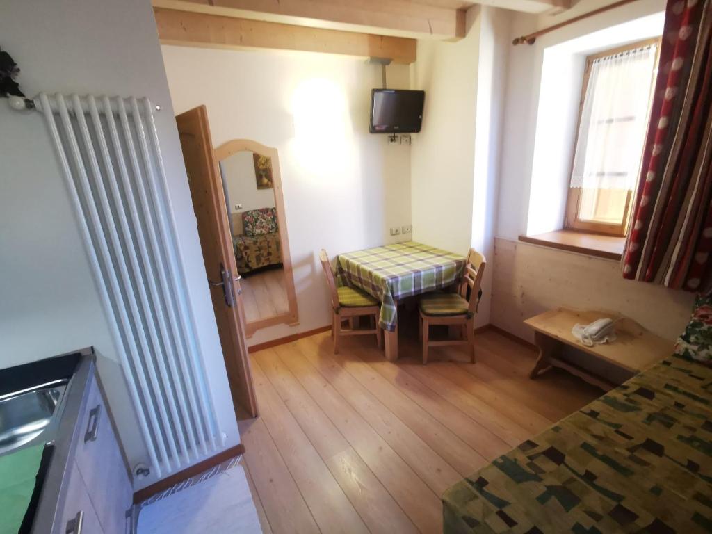 um pequeno quarto com uma mesa e uma janela em Agritur Masi Brenta em Rovereto