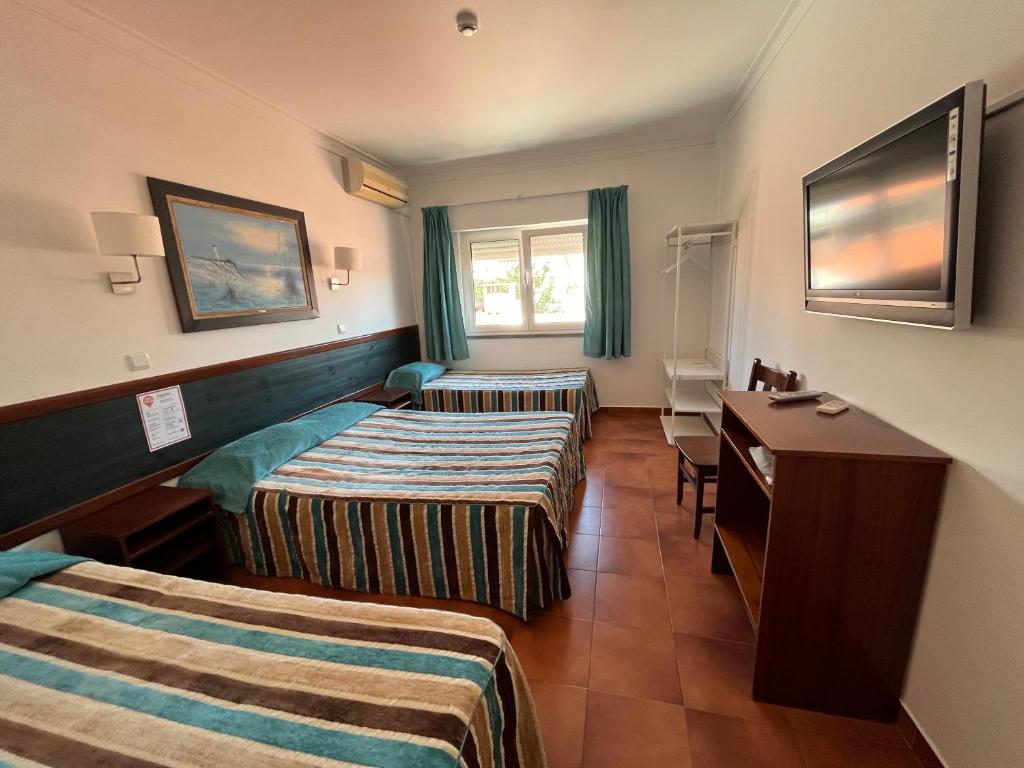a hotel room with two beds and a desk at O Cantinho in Benavente