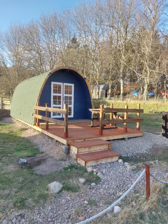 a yurt with two benches and a wooden deck at Pod 4 in Skail