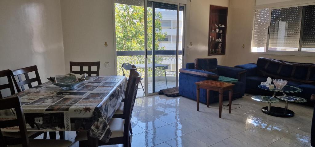 uma sala de estar com uma mesa e um sofá azul em Appartement quiet sympa Rabat em Rabat