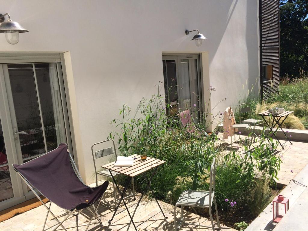 d'une terrasse avec une table et des chaises dans le jardin. dans l'établissement Denis & Virginie - château à pied - parking gratuit, à Versailles