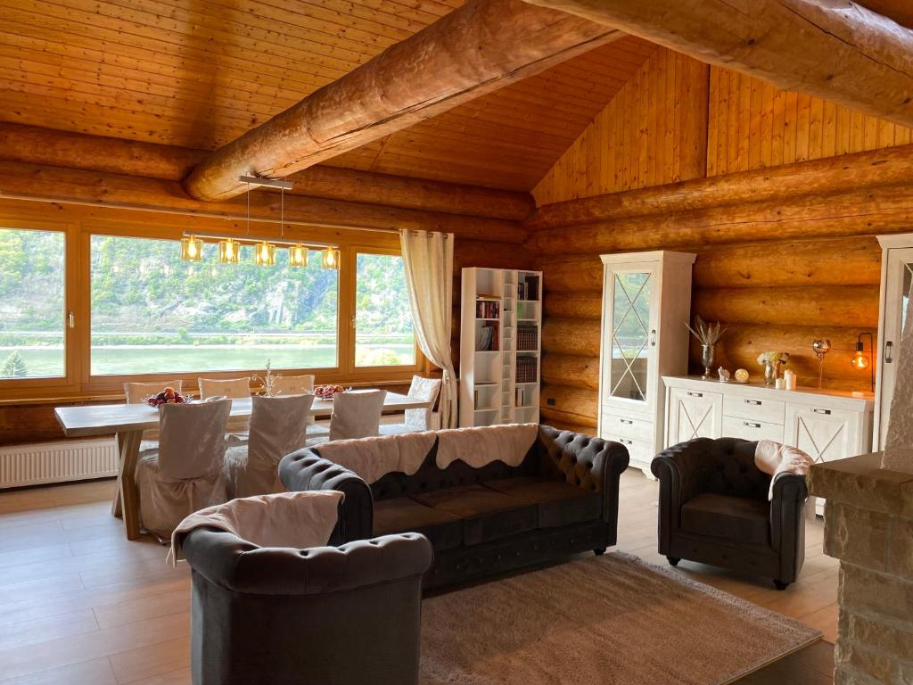 una sala de estar con sofá y sillas en una cabaña en Traumhaftes Blockhaus am Rhein, en Kamp-Bornhofen