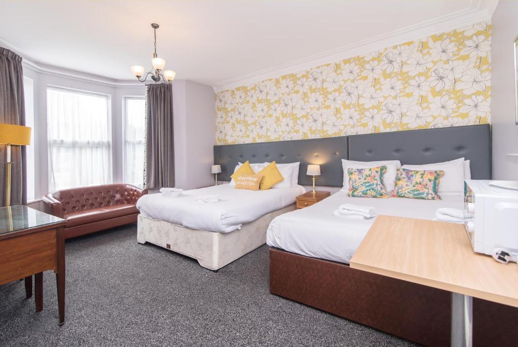 Habitación de hotel con 2 camas y escritorio en The Linden Leaf Rooms - Classy & Stylish, en Nottingham