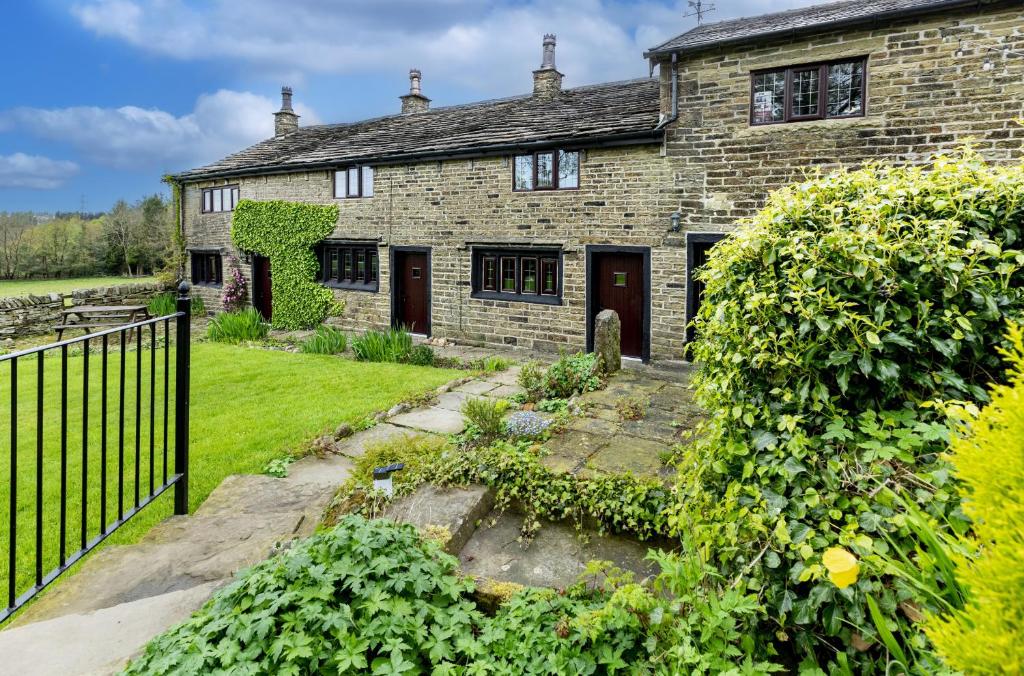 una casa de ladrillo con una puerta y un patio en Finest Retreats - Ellen's Cottage, en Bury