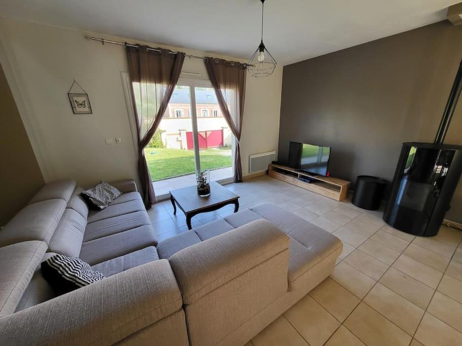 a living room with a couch and a television at L&#39;écureuil de la Baie - maison en Baie de Somme in Mons-Boubert
