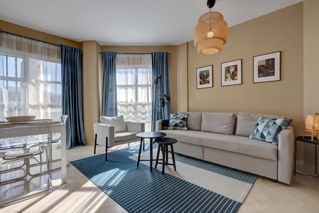 een woonkamer met een bank en een tafel bij 053 - Two Bed Mijas Golf Apartment in popular Matchroom Golf Club in Fuengirola