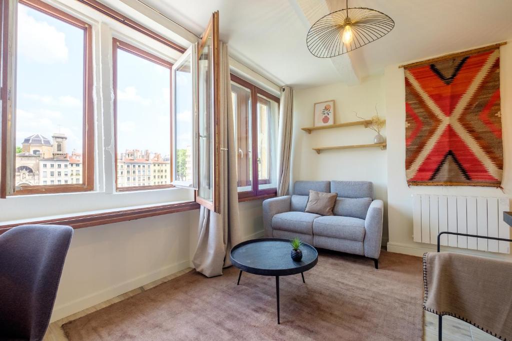 un salon avec un canapé et une table dans l'établissement HONORÊ SUITE SAINT PAUL, à Lyon