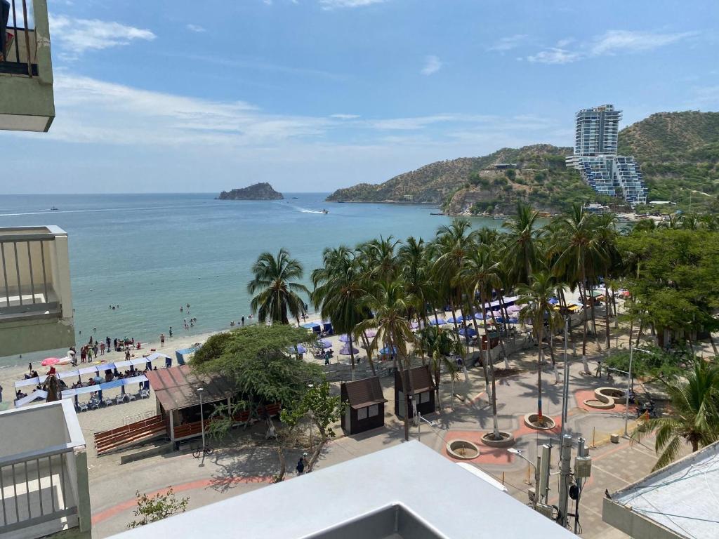 uma vista para uma praia com palmeiras e para o oceano em Apartamento Tacoa 703 em Santa Marta