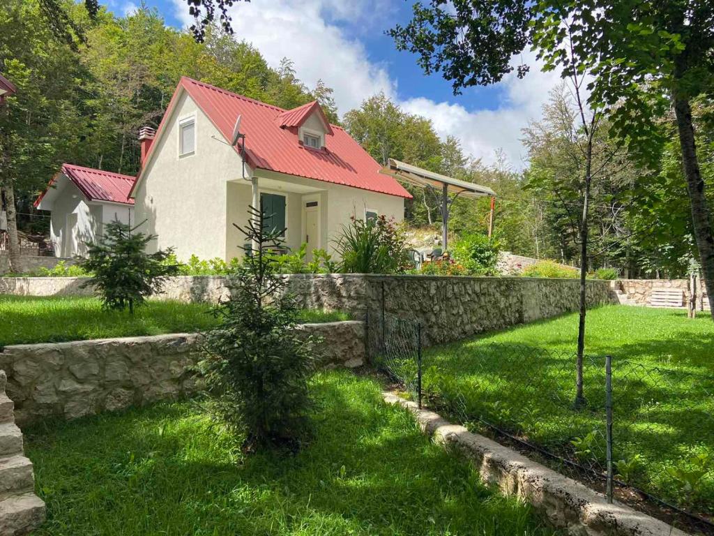 a house with a stone wall in a yard at Mountain house Ivanova Korita in Cetinje