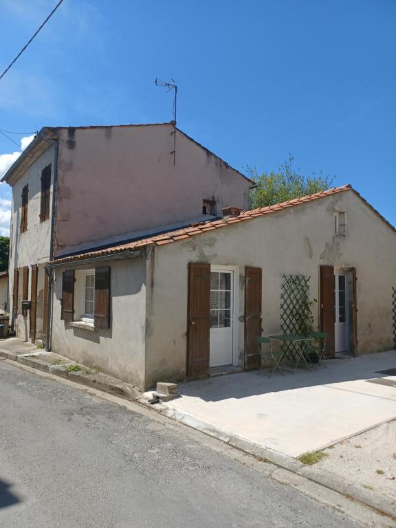 ein altes Haus am Straßenrand in der Unterkunft Maison de village entre estuaire et océan in Saint-Yzans-de-Médoc
