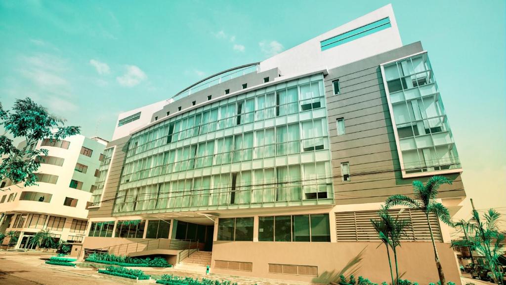 un grande edificio con vetrate e palme di Hotel Puerto Pacifico Guayaquil Airport a Guayaquil