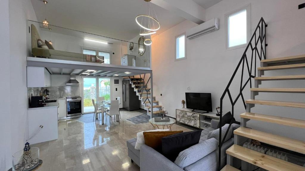 una sala de estar con sofá y una escalera en una casa en Victoria's Suites Corfu en Lefkímmi