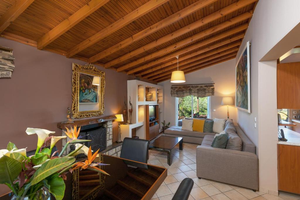 a living room with a couch and a fireplace at Villa René in Koskinou