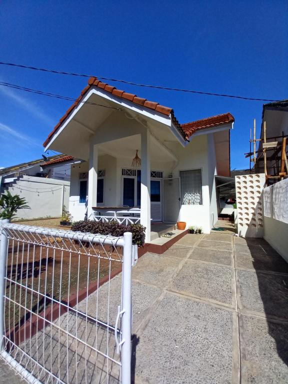 une maison avec une clôture devant elle dans l'établissement Shambala palm beach anyer, à Anyer