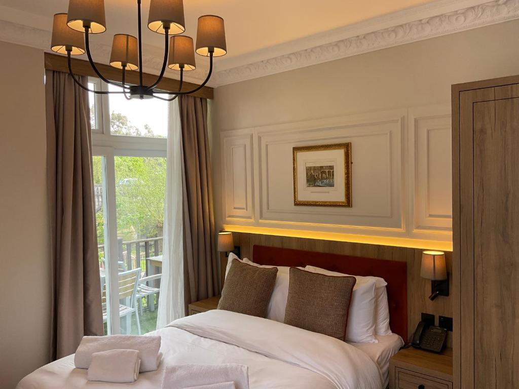 
a bedroom with a large bed and a large window at Old Mill Hotel & Lodge in Bath
