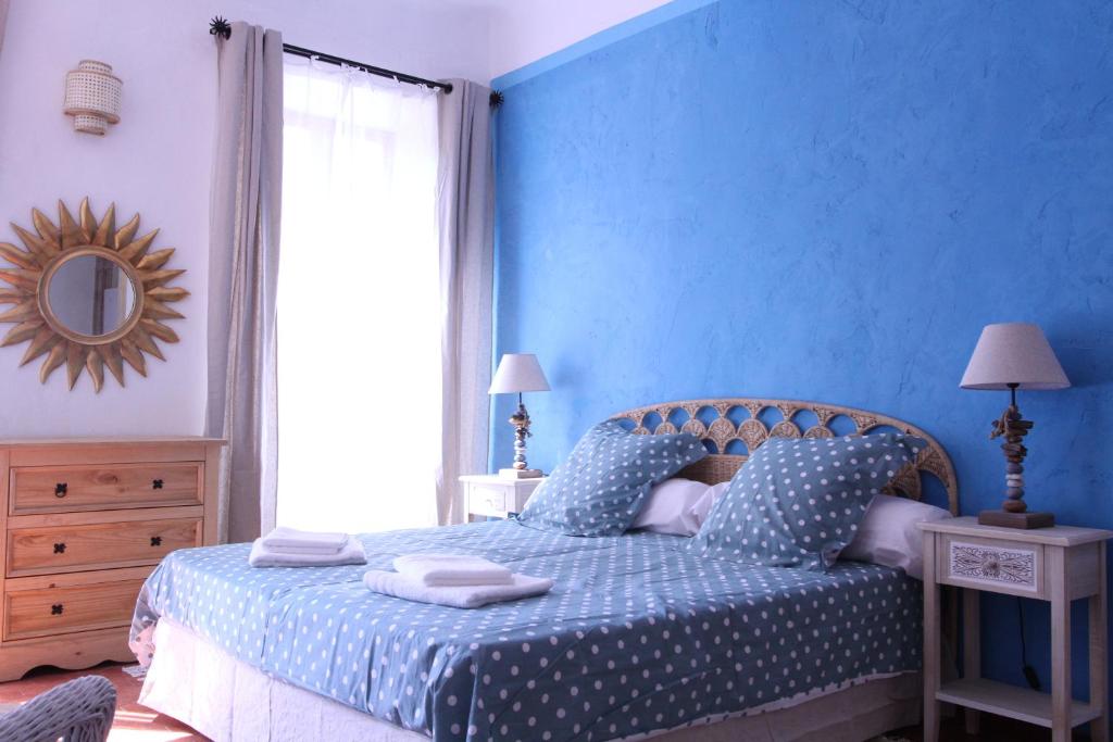 ein blaues Schlafzimmer mit einem Bett mit blauer Wand in der Unterkunft Studio la maison bleue in Cotignac