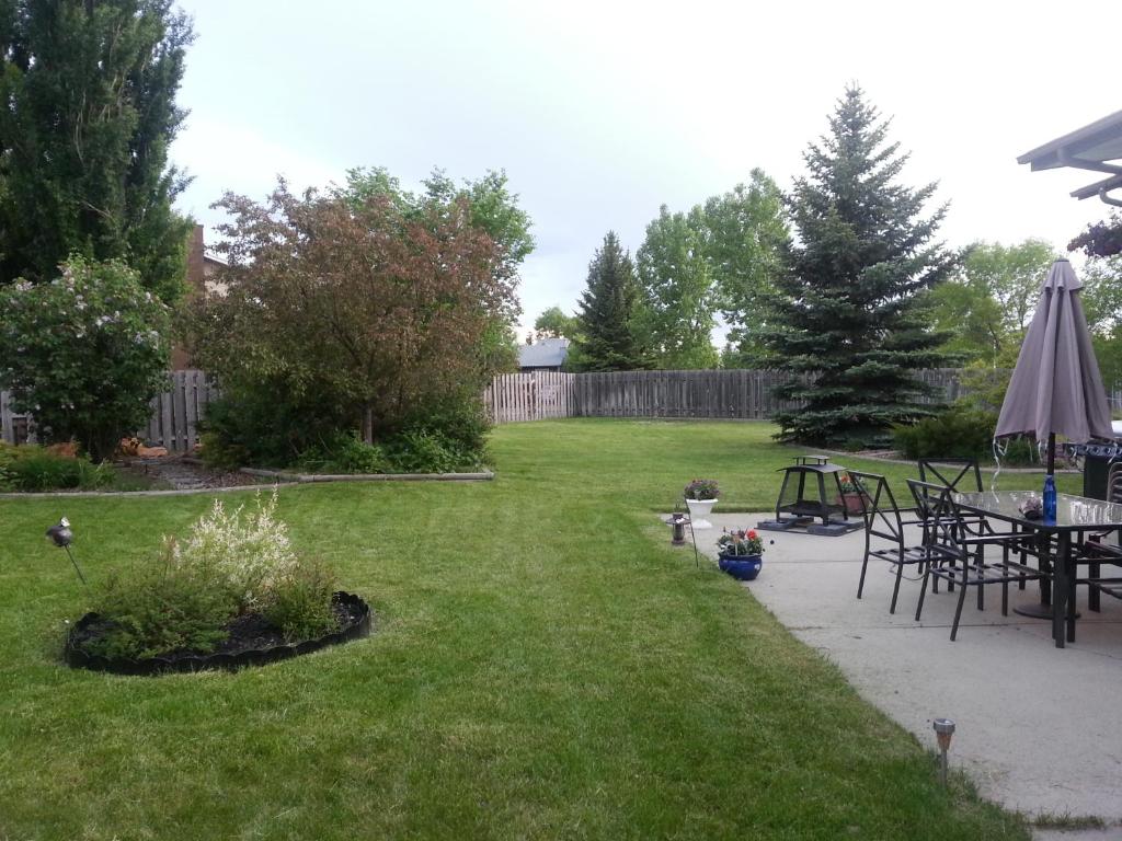a yard with a table and an umbrella at Main Floor Bright & Spacious Apartment in Lethbridge