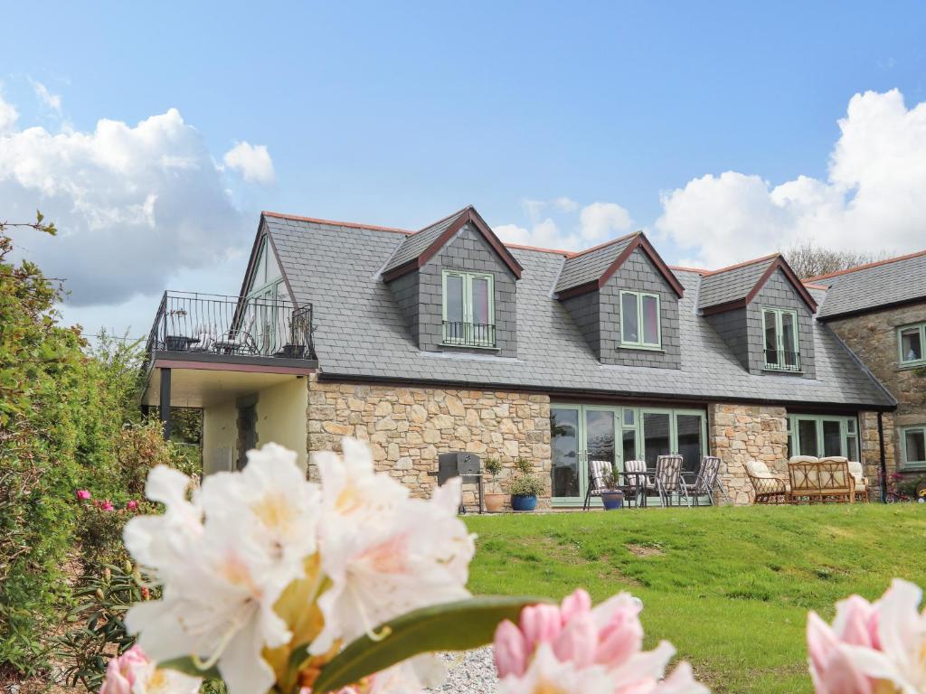 uma casa com flores em frente em Higher Kernick View em Bodmin