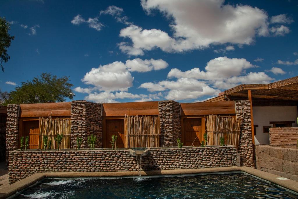 una casa con piscina frente a ella en Terrantai Lodge en San Pedro de Atacama