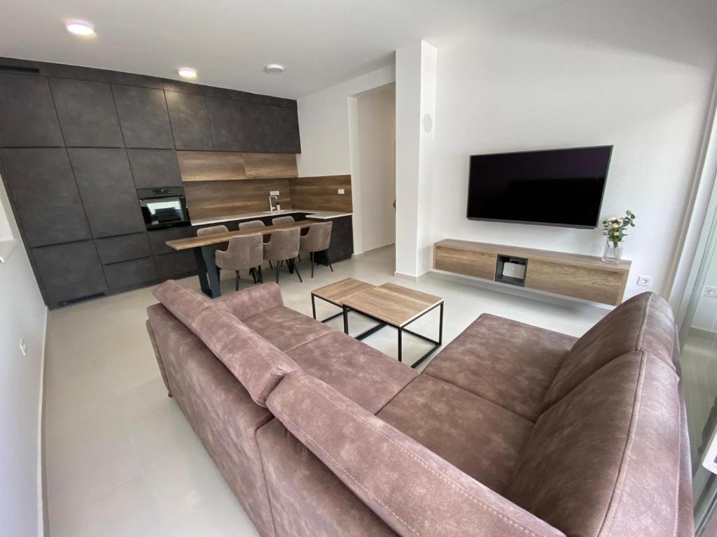 sala de estar con sofá marrón y mesa en Apartman Emanuel en Vodice