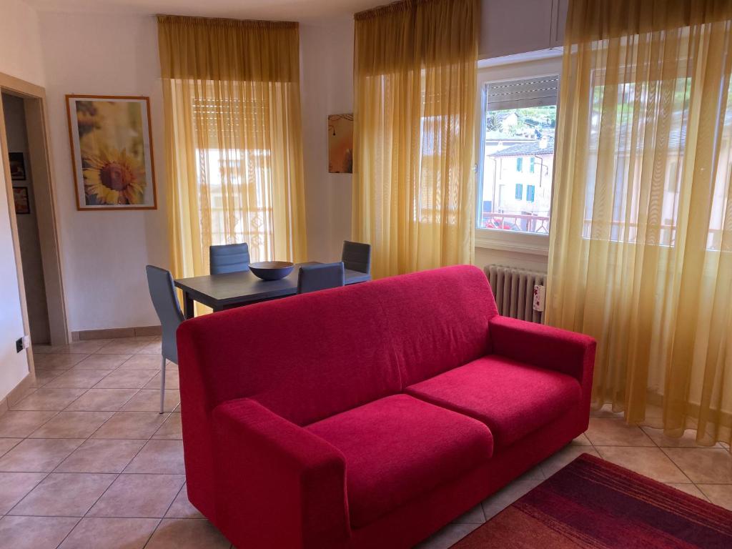 een woonkamer met een rode bank en een tafel bij La Torre in Tirano