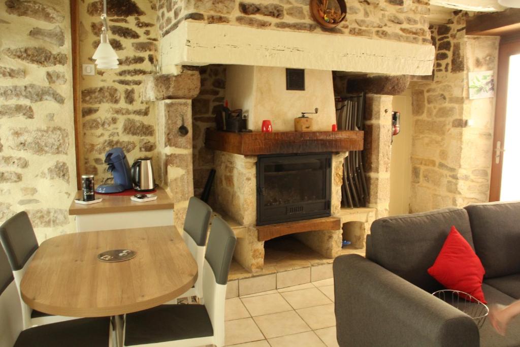 a living room with a table and a fireplace at gite de la rue droite in Turenne