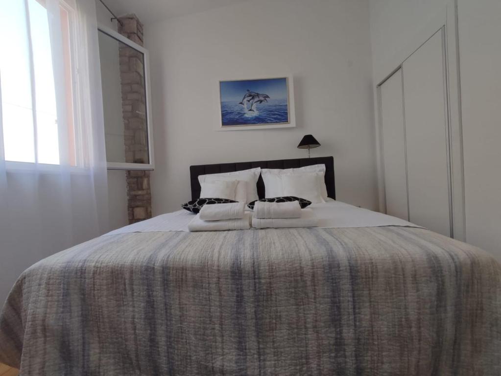 una camera bianca con un grande letto con una coperta di Apartment Sandrica a Stomorska