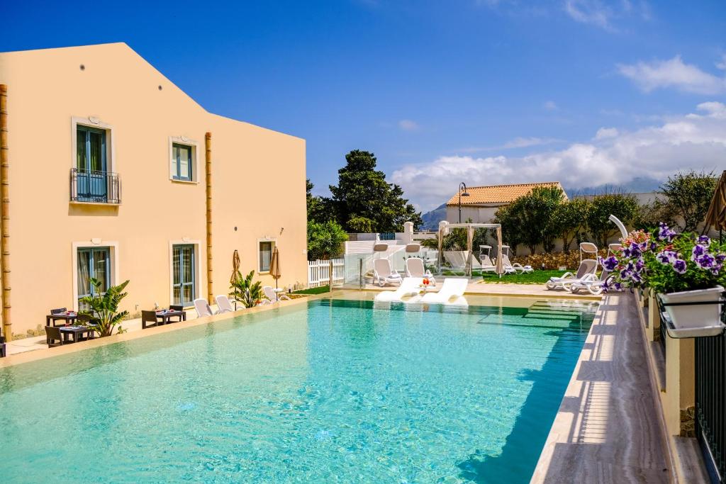 a large swimming pool next to a building at Hotel Baglio Di Scopello in Scopello