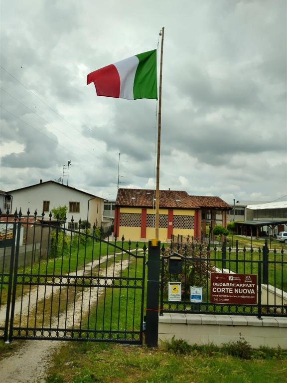 a flag on a fence in front of a building at Corte Nuova B&B in Bagnolo San Vito