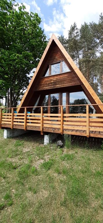 a large wooden house in a field with trees at Domki pod Dębami in Trzcianka