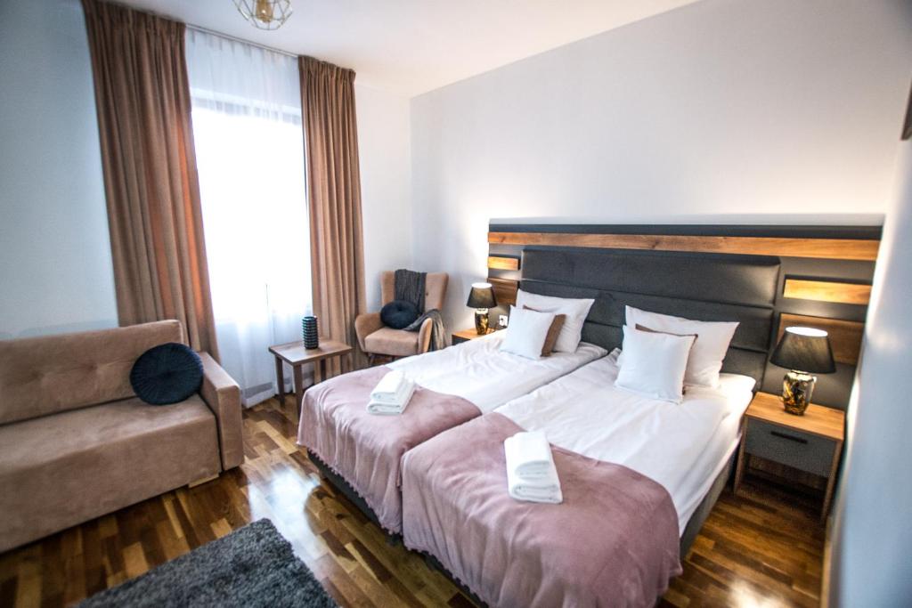 a hotel room with a large bed and a couch at Hotel Sukcesor in Zamość
