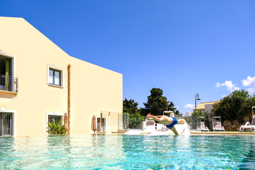 a person in the water at a swimming pool at Hotel Baglio Di Scopello in Scopello
