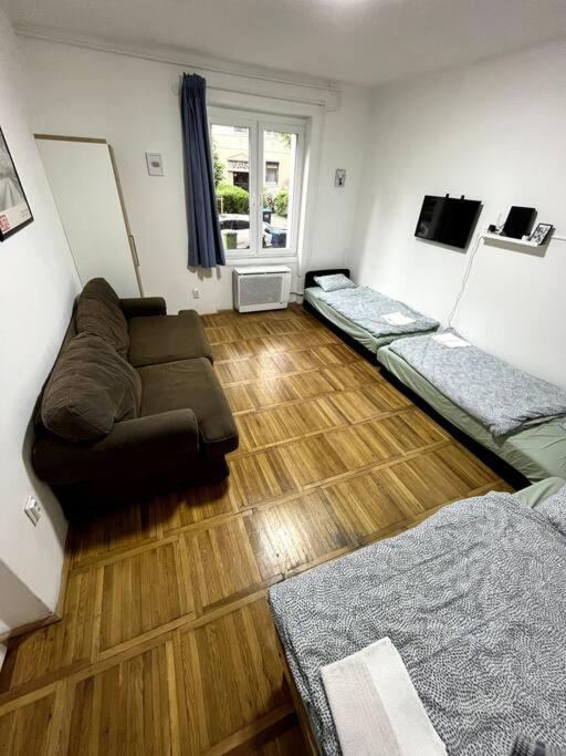een woonkamer met 3 bedden en een bank bij Hangulatos lakás Budapest zöld övezetében in Boedapest
