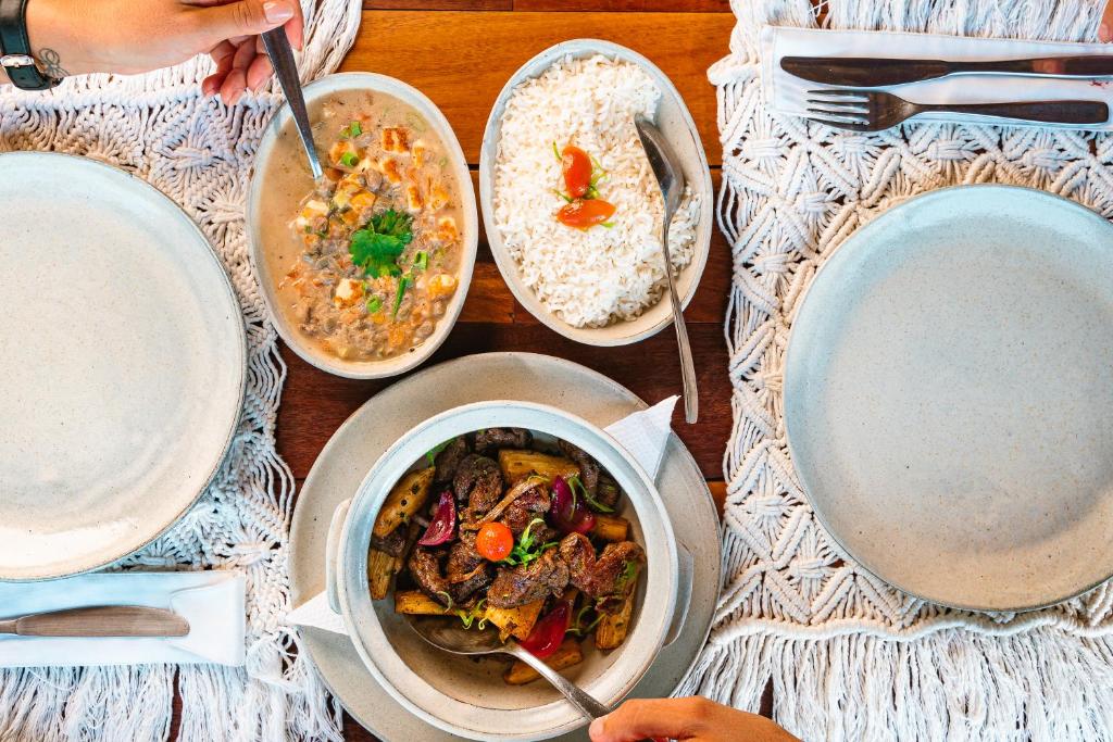 Vila Kalango في يريكوكورا: طاولة مليئة بأطباق الطعام مع الأرز