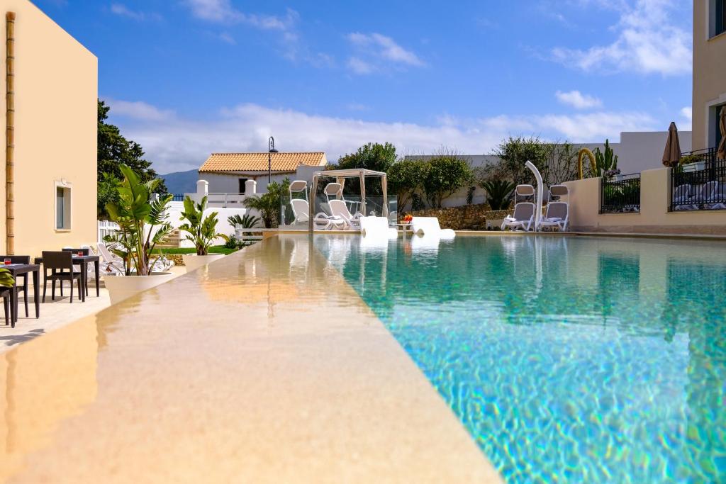 a swimming pool with blue water in a house at Hotel Baglio Di Scopello in Scopello