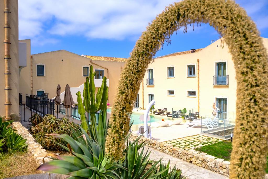 a resort with a pool and a building at Hotel Baglio Di Scopello in Scopello