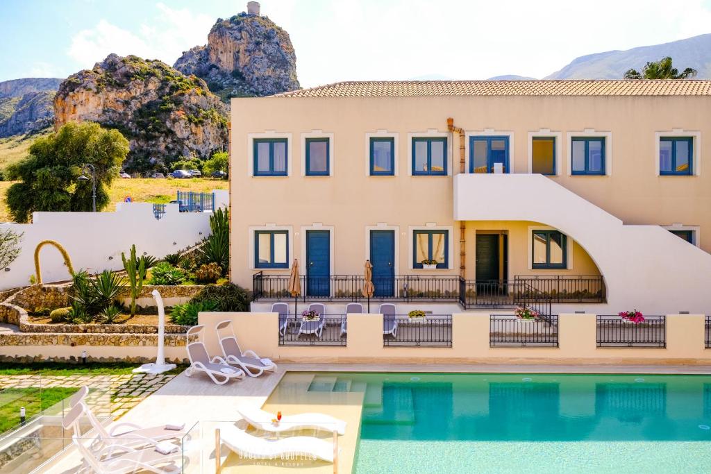 a villa with a swimming pool and a house at Hotel Baglio Di Scopello in Scopello