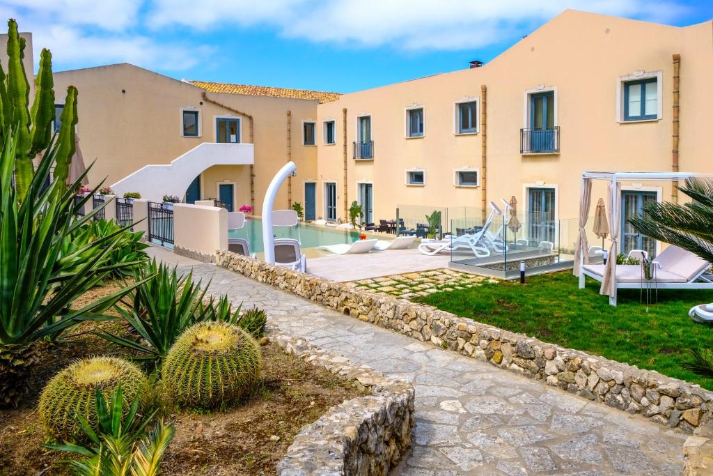 a villa with a garden and a resort at Hotel Baglio Di Scopello in Scopello