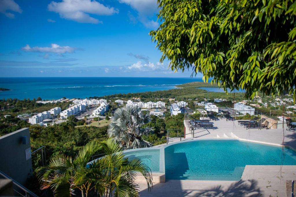 a view of a resort with a swimming pool and the ocean at Happy Days Villa A in Fajardo